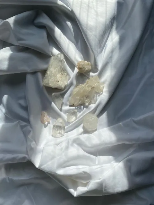 Hand arranging black tourmaline and clear quartz on leather cord