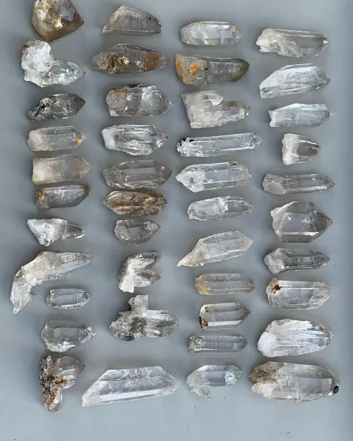 Hand holding clear quartz and citrine toward sunlight