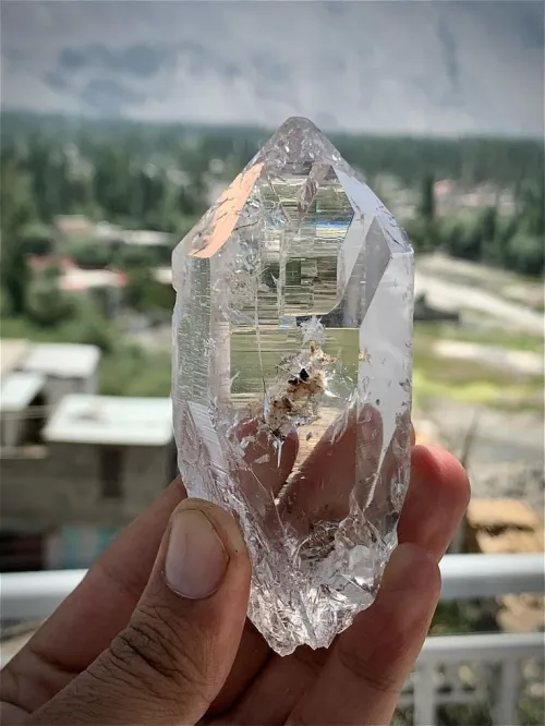 Hands holding carnelian and quartz crystals together