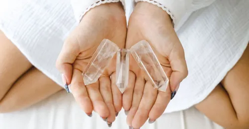 Person holding real and fake clear quartz comparison