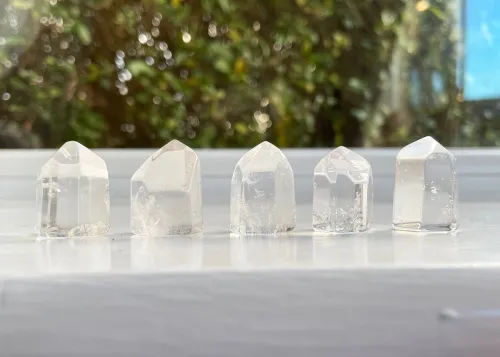 Person meditating with clear quartz crystal