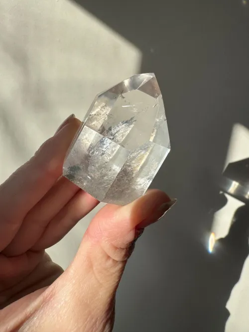 Woman meditating with clear quartz point